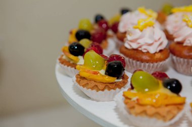 ahududu, üzüm ve şeftali bir düğün tablo ile cupcakes.