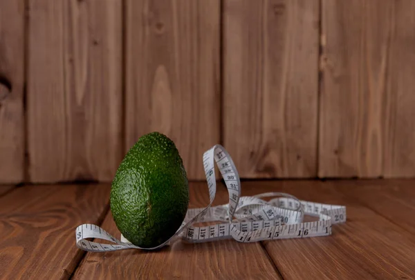 Avocado and meter on a wooden background. Diet food concept. Diet food ingredient.