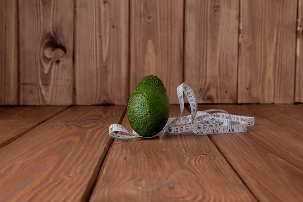 Avocado and meter on a wooden background. Diet food concept. Diet food ingredient.