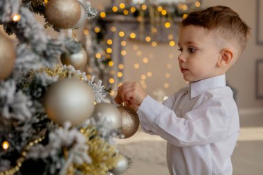 küçük çocuk Noel için bir Noel ağacı süsle.