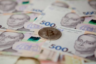Ukrayna Hryvnia 'sının arka planına karşı Bitcoin.