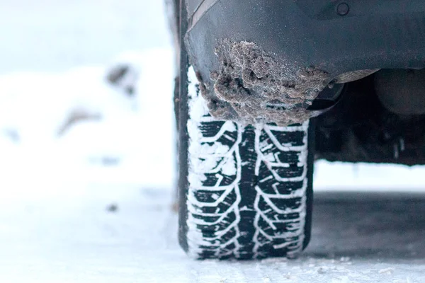 Primo piano degli pneumatici per auto in inverno su strada innevata — Foto Stock