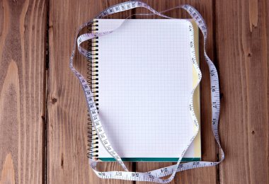 Diyet planı konsepti. Mavi ahşap arka planda yazılı diyet planlı bant ve kağıt defter ölçüyorum. Sağlıklı zayıflatma diyeti ve zindelik kavramı.