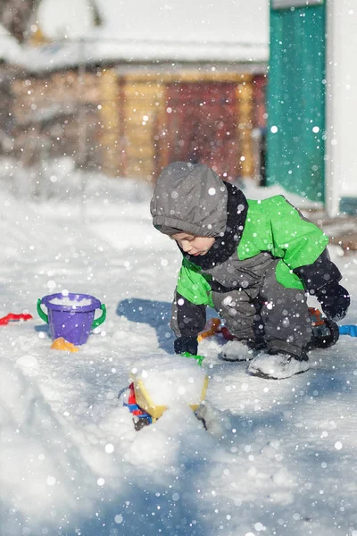 Porträt Eines Niedlichen Kleinkindes Das Auf Schnee Sitzt Und Mit — Stockfoto