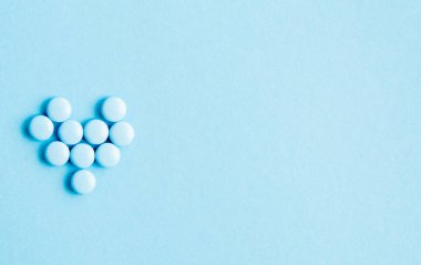 Hapları kalp üzerinde mavi arka plan, üstten görünüm.