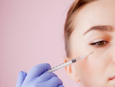 Doktor güzellik uzmanı sıkma ve bir güzellik salonu içinde güzel, genç bir kadının yüz cilt kırışıklıkları yumuşatma için Botulinotoxin enjeksiyon yordam bulunur. Kozmetik Cilt Bakımı.
