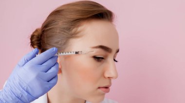 Doktor güzellik uzmanı sıkma ve bir güzellik salonu içinde güzel, genç bir kadının yüz cilt kırışıklıkları yumuşatma için Botulinotoxin enjeksiyon yordam bulunur. Kozmetik Cilt Bakımı.