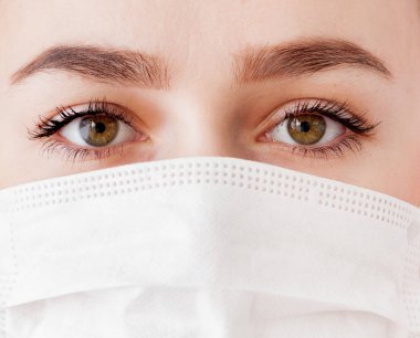 Tıbbi maske genç bir kadın portresi. Virüslere karşı koruma.