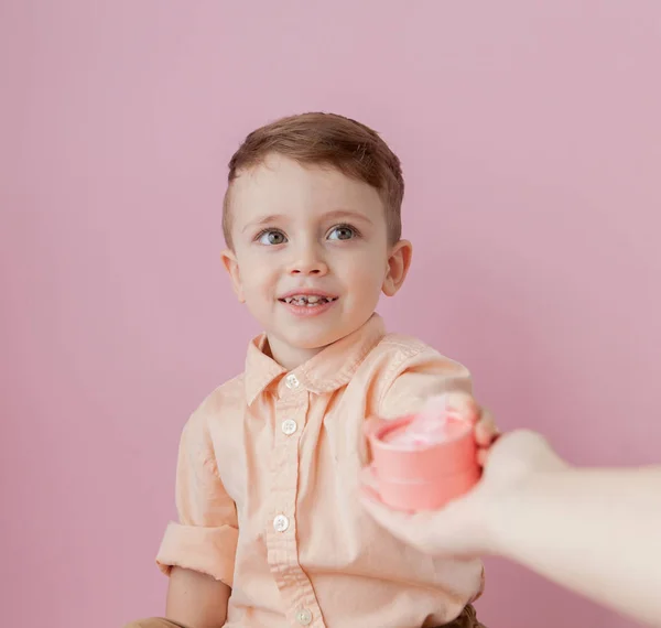 Um rapazinho feliz com um dom. Foto isolada em fundo rosa. Rapaz sorridente segura a caixa de presente. Conceito de feriados e aniversário — Fotografia de Stock