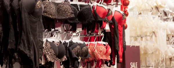 Anunciar, Venta, Concepto de moda - Primer plano de la mano de las mujeres elegir ropa interior en perchas en el supermercado — Foto de Stock