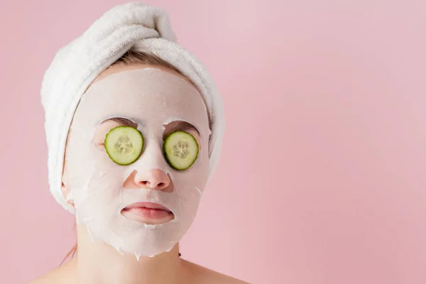 Krásná Mladá Žena Použití Kosmetické Tkáňové Masky Tváři Okurkou Růžovém — Stock fotografie