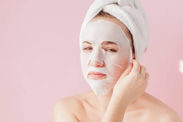 Güzel Genç Kadın Kozmetik Doku Maske Pembe Bir Arka Plan — Stok fotoğraf