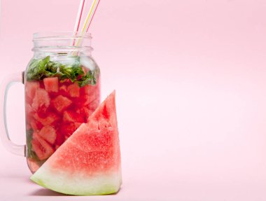 Karpuz smoothie meyve dilim ve pembe bir arka plan, kopya alanı, üzerine nane yaprağı ile yakın çekim.