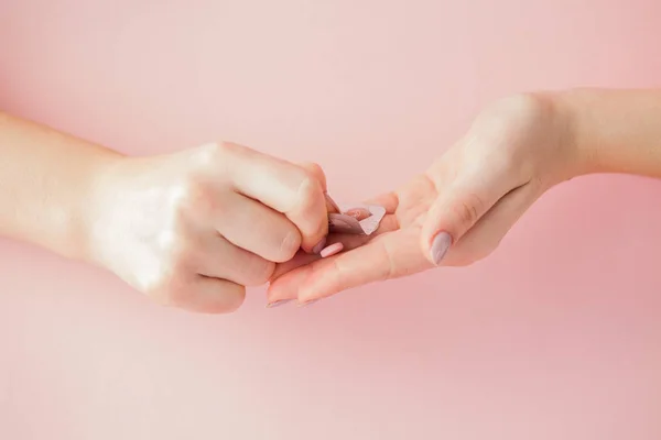 Roze Pillen Tabletten Bij Vrouw Hand Roze Achtergrond Bovenaanzicht Flat — Stockfoto