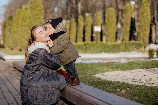 Feliz niño besando a la madre al aire libre. Día de la Madre — Foto de Stock