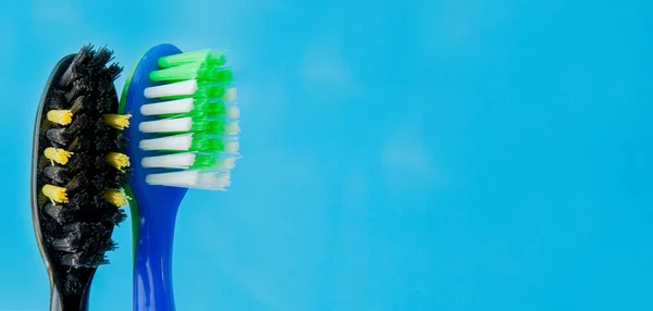 Set of toothbrushes in glass on blue background. Concept toothbrush selection, copy space — Stock Photo, Image