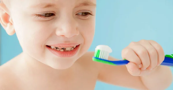 Портрет маленького хлопчика з зубною щіткою на синьому фоні — стокове фото