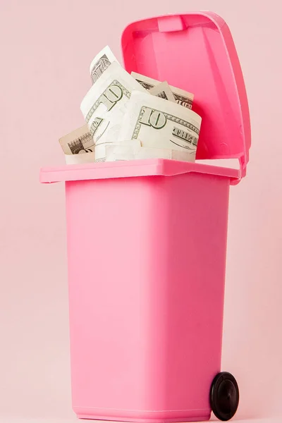 Dollar sedlar i rosa soptunna på rosa bakgrund — Stockfoto