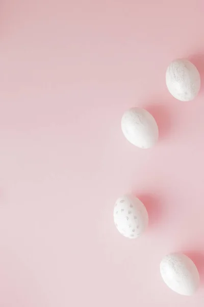 Huevos de Pascua blancos sobre fondo rosa con espacio para copiar. Vista superior plano de decoración arreglo Feliz Pascua concepto de fondo de vacaciones. Diseño de tono pastel en la posición plana mínima —  Fotos de Stock