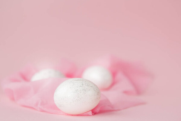 White Easter eggs on pink background with copy space. Top view shot of arrangement decoration Happy Easter holiday background concept. Design pastel tone in minimal flat lay