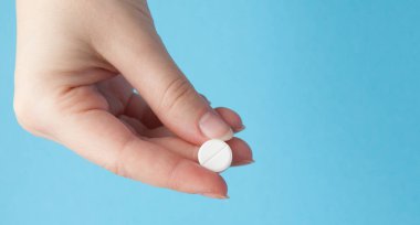 Bir ilaç üzerinde mavi arka plan izole hemşirenin elinde yakın çekim shot