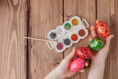 Kadının el ahşap arka plan üstünde Paskalya yumurta boyama Close-Up