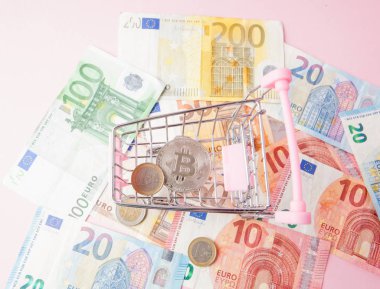 alışveriş sepeti ile bitcoin euro para tasarrufu için gelecek, ethereum cryptocurrency, blockchain iş teknoloji kavramı, pembe bir arka plan metin için arka plan üzerinde oyuncak kapatın