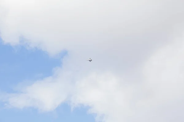 Military fighter in the blue sky with white clouds — Stock Photo, Image