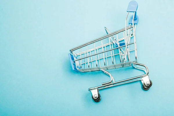 Blå shopping vagn på blå bakgrund, kopia utrymme, minimalistisk stil — Stockfoto