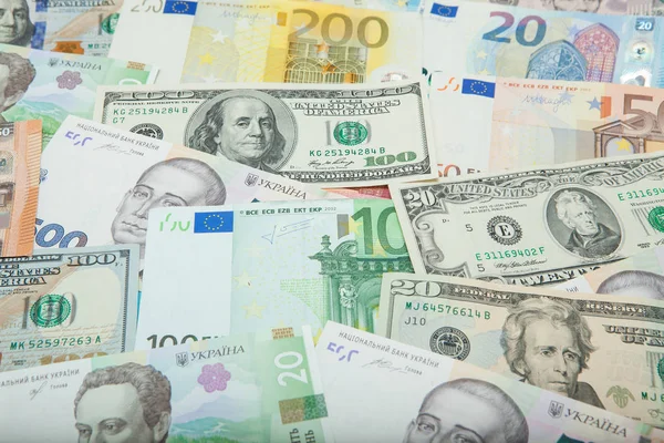 Geld und Finanzkonzept. Hundert-Dollar-Schein auf buntem abstrakten Hintergrund ukrainischer, amerikanischer und Euro-Banknoten — Stockfoto