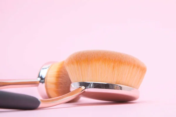 Set med ovala borstar för makeup på rosa bakgrund — Stockfoto