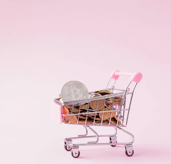 Bitcoin en -munten in de winkelwagen op roze achtergrond — Stockfoto
