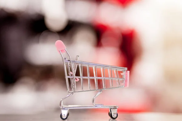 Carrito de compras vacío con desenfoque abstracto supermercado tienda de descuento pasillo y estantes de productos interior fondo desenfocado —  Fotos de Stock