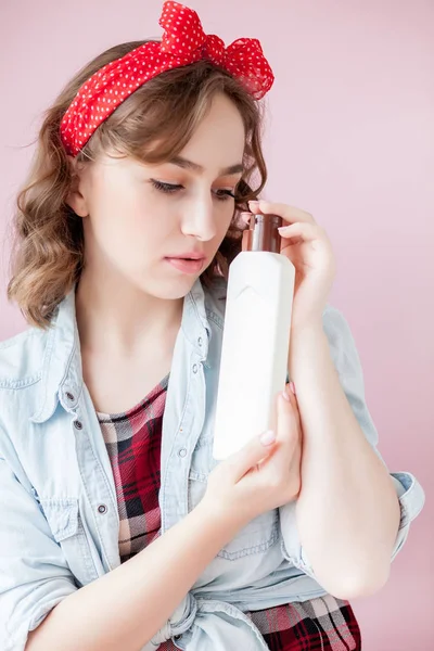 Gyönyörű fiatal nő, pin-up smink és frizura, tisztító eszközök, rózsaszín háttér — Stock Fotó