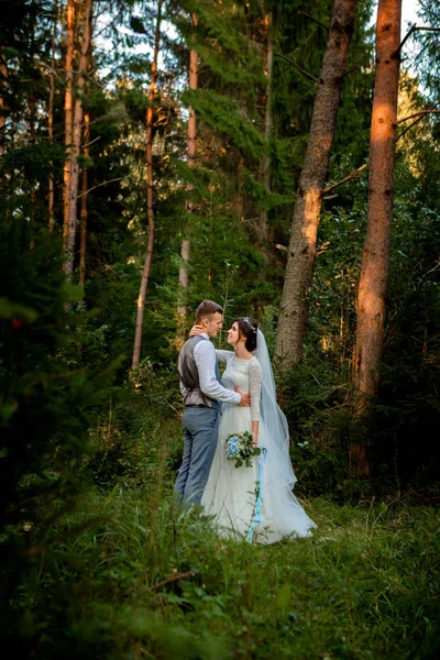 Bella coppia di sposi che cammina nella foresta. Siamo in luna di miele. Sposo e sposo che si tengono per mano nella pineta, foto per San Valentino — Foto Stock