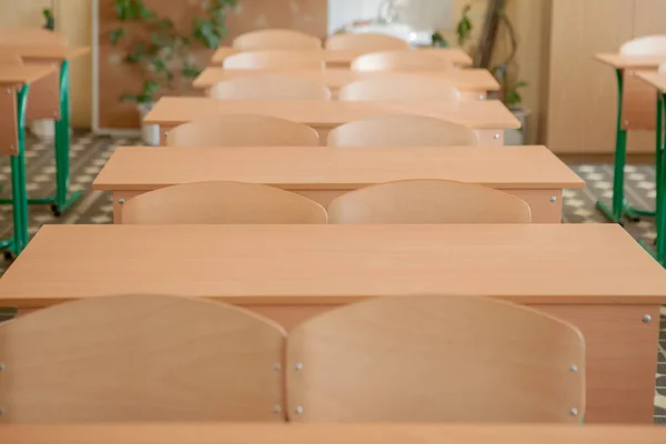 Interno di aula vuota con sedie e scrivanie in fila — Foto Stock