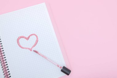 Kalp bir ruj bir defter üzerinde pembe bir bac ile boyanır