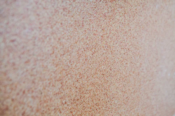 Sobre el fondo de arena diseminada pequeña grava, una miga de piedra. La textura de la superficie de la pared, el color claro — Foto de Stock