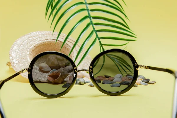 Sommerurlaub. tropisches Sommerkonzept mit Accessoires für Damenmode, Blättern und Muscheln auf gelbem Hintergrund. flache Lage, Draufsicht — Stockfoto