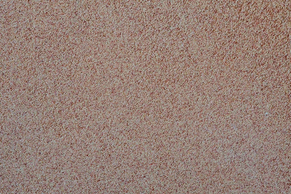 Mot bakgrund av spridd sand små grus, en sten smulor. Textur av en yta på en vägg, ljus färg — Stockfoto