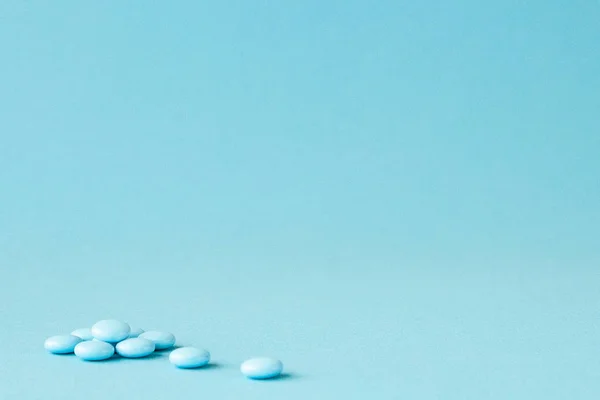 Pílulas azuis no fundo azul com espaço de cópia — Fotografia de Stock