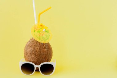 Sarı arka planda bir pipet ile taze Hindistan cevizi kokteyli, kopya alanı
