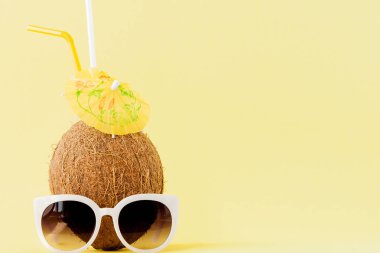Sarı arka planda bir pipet ile taze Hindistan cevizi kokteyli, kopya alanı