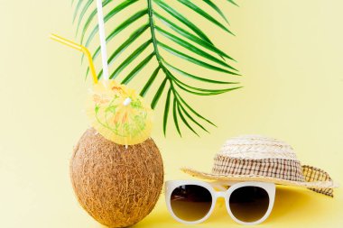 Sarı arka planda bir pipet ile taze Hindistan cevizi kokteyli