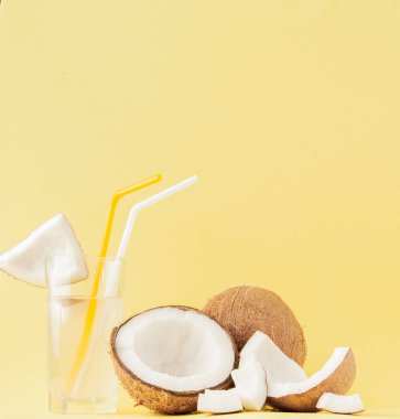 Sarı arka planda bir pipet ile taze Hindistan cevizi kokteyli, kopya alanı