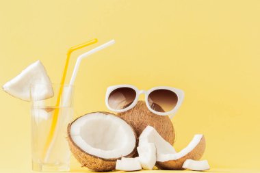 Sarı arka planda bir pipet ile taze Hindistan cevizi kokteyli