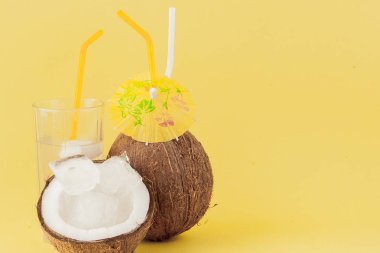 Sarı arka planda bir pipet ile taze Hindistan cevizi kokteyli, kopya alanı