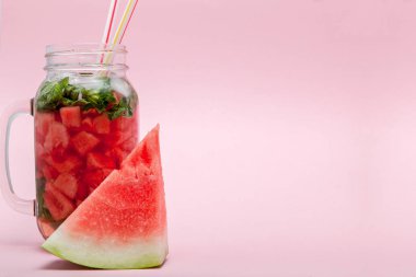 Karpuz smoothie meyve dilim ve pembe bir arka plan, kopya alanı, üzerine nane yaprağı ile yakın çekim
