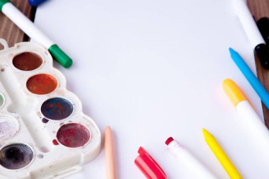 Beyaz kağıdın bir ahşap, yakın, kurşun kalem, boya ve işaretleri açayım. Okula dönüş. okul ve ofis malzemeleri. Eğitim ve okul kavramı ve kopya alanı ahşap arka plan üzerinde kenarlık