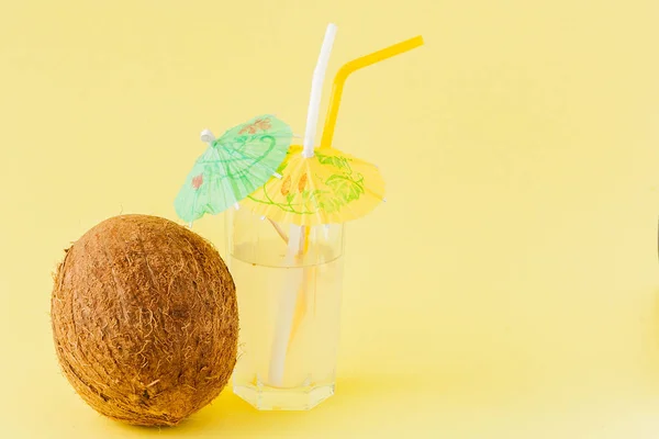 Cóctel de coco fresco con pajitas sobre fondo amarillo, espacio para copiar — Foto de Stock